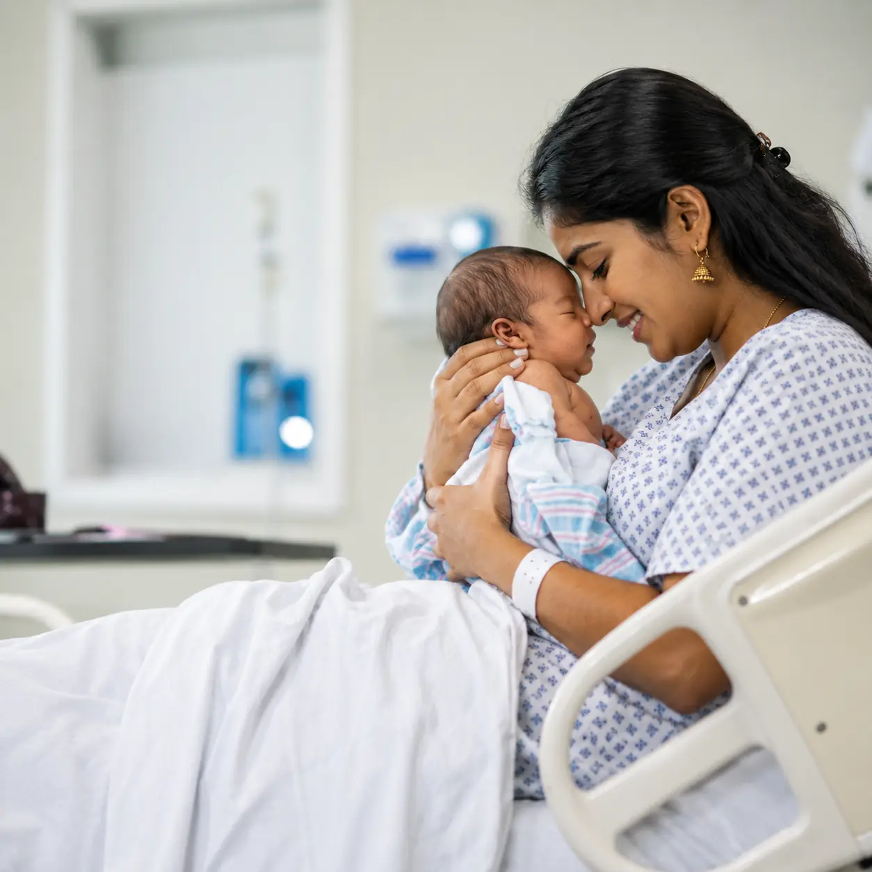 Mother holding her newborn baby at Unittas Hospital maternity ward in Chennai
